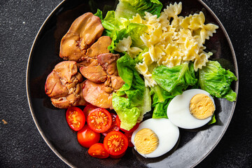 salad chicken liver, pasta, tomato, green leaf lettuce, boiled egg, farfalle snack meal food on the table copy space food background rustic top view