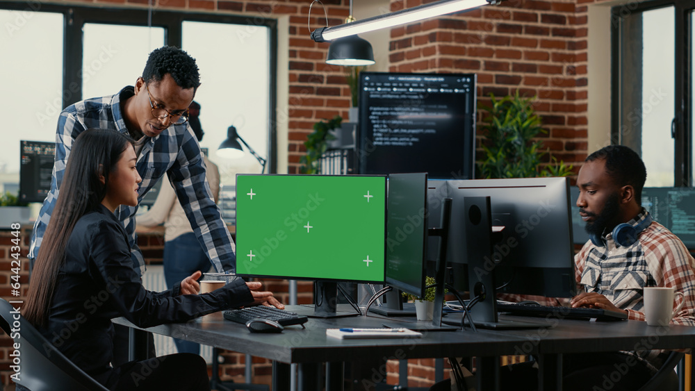 Fototapete Two software developers analyzing source code looking at green screen chroma key mockup with coworker sitting at desk writing algorithm. Software developers working on artificial intelligence project.