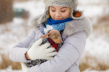 Woman hug warming her little dog in winter