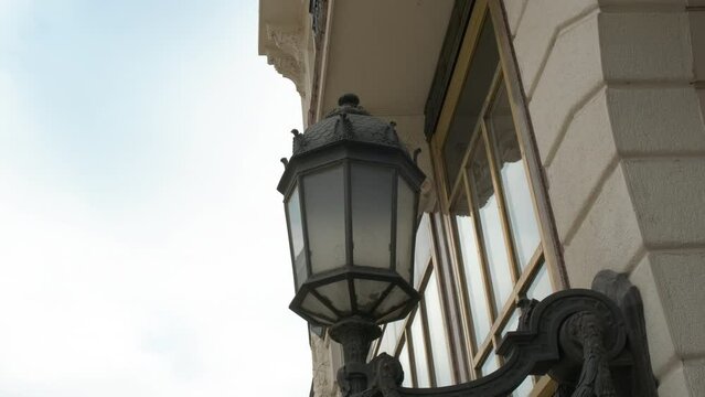 Vintage street lamp on white wall in day. A view of nice vintage street lamp on the old wall in the city road.