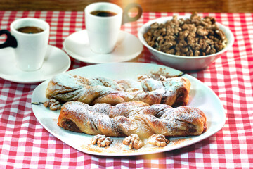 Baking strudel with walnuts and coffee on the table, crispy walnut cake,  