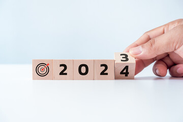 2024 Happy New Year's Eve wooden blocks flip change hand white background. Countdown starting...