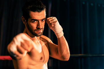 Boxing fighter shirtless posing, caucasian boxer punch his bare fist and wrap in front of camera,...