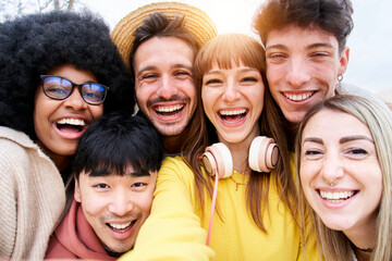 Obraz premium Selfie of a group of multiracial students and laughing a lot while they they look at camera. They look happy and friendly faces. Portrait of a community of millennial generation people