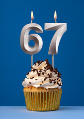 Vertical birthday card with cake - Lit candle number 67 on blue background