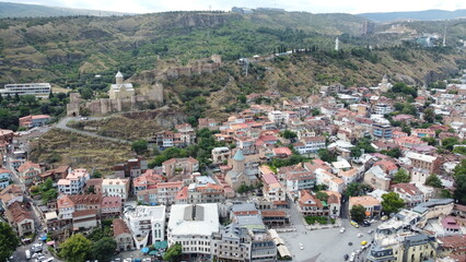 A drone shot of Old Tbilisi incorporating the Mother of Georgia, and Narkala Fortress in the background.