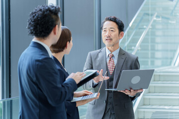 階段の前で立ち話をするビジネスパーソン