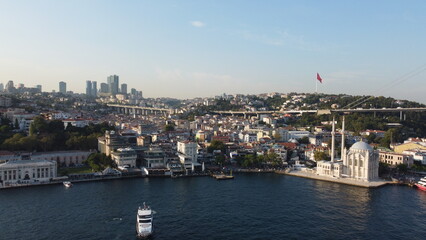 A drone shot of the Grand Mecidiye Mosque, Ortaköy, Istanbul, with the skyline of the city and Bosphorus in the background