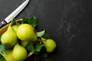 Fresh pears on a dark table.Pears on a wooden background. Fruit harvest. Autumn still life.Top view. Flat lay. Copyspace