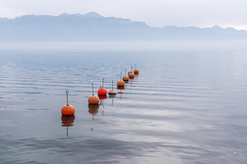 Mooring buoys on the lake Leman, Switzerland on a foggy day.