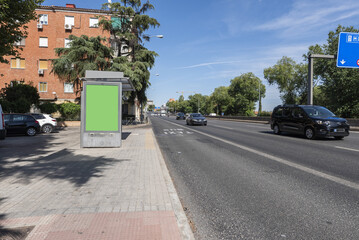 A street leading out of the city next to low-rise residential buildings