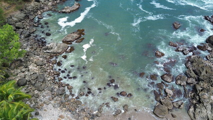 Drone view The beauty of the beach with cliffs, waves and trees on Karang Agung beach, Kebumen, Central Java, Indonesia