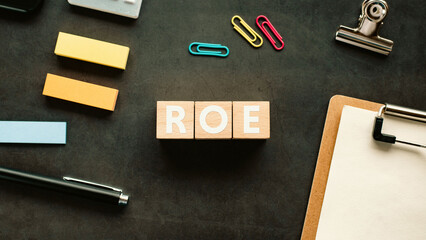 There is wood cube with the word ROE. It is an abbreviation for Return On Equity as eye-catching image.