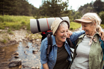 Happy senior lesbian couple hiking together in the forest