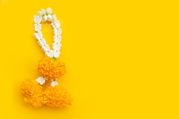 Obraz premium Jasmine garland with marigold flower on yellow background
