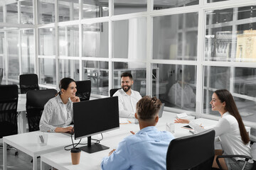 Colleagues working together in open plan office