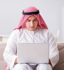 Young arab businessman working with laptop on sofa