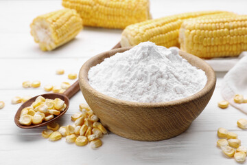 Bowl with corn starch and kernels on white table
