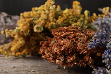 Many different dry herbs on wooden table, closeup