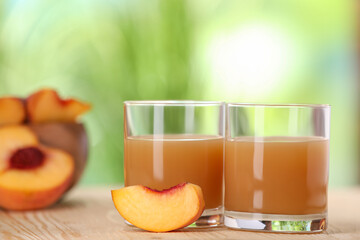 Tasty peach juice and fresh fruit on wooden table outdoors, closeup