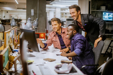 Young diverse group of businessmen using a computer in the office of a startup company