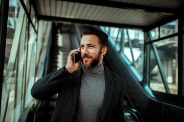Young man talking on his phone while in a train station