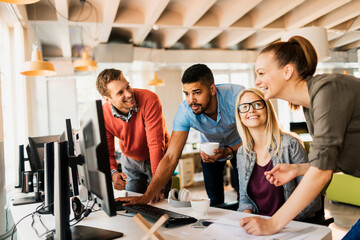 Young and diverse group of coworkers working together on a project in a startup company office
