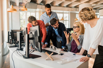 Young and diverse group of coworkers working together on a project in a startup company office