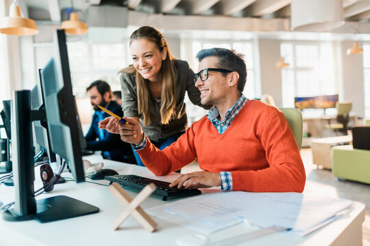 Young coworkers using the computer in a startup company office