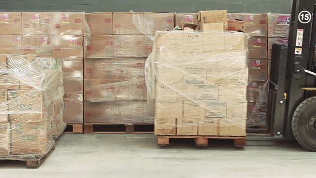 Forklift Truck Moving Packages Inside a Factory. 4K Resolution.