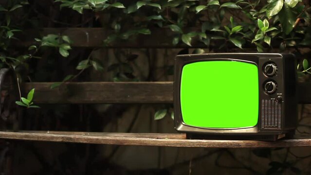 Retro Television Turning On Green Screen in a City Park. Close Up. 4K Resolution.