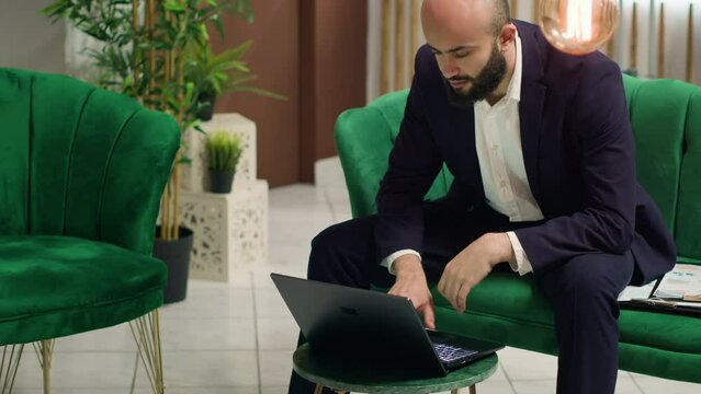 Entrepreneur working on project ideas while he waits in lounge area, business trip. Manager sent to negociate with collaborators to ensure partnership for company growth on global stage.