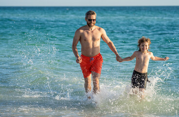 daddy and son running in sea beach. Father son child bonding enjoying summer vacation. Special moments between daddy and son at sea. Father son kid bonding relationship. splashes of happiness