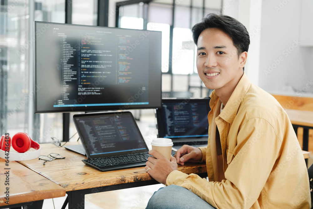 Wall mural young programmer working on desktop pc in office of software company.
