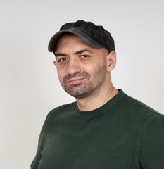 Portrait of a handsome rugged young man wearing a black military cap.