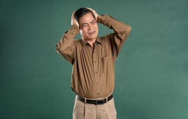 portrait of middle aged asian man posing on blue background