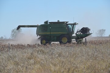 Australian farmer in Combine harvester harvesting a field in Queensland Australia