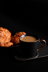 Hot latte coffee with Croissant coffee break isolated in black background