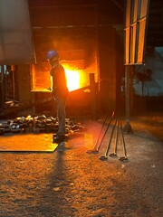 A blacksmith's furnace which uses a flame tongue with a metal rod.