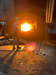 A blacksmith's furnace which uses a flame tongue with a metal rod.