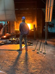 A blacksmith's furnace which uses a flame tongue with a metal rod.