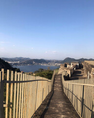 Obraz premium Descent ramp with railings on both sides in a fort overlooking the sea and mountains. clear sky day