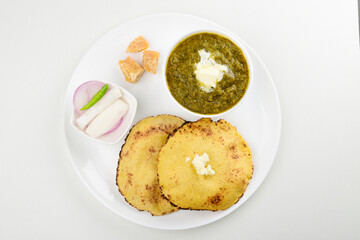 Top view of saag and makki roti with white butter isolated on white background