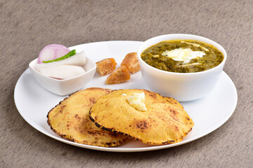 Punjabi meal saag and makki roti with salad in plate