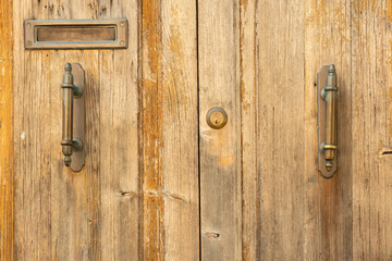 Part of an old wooden door with metal handles