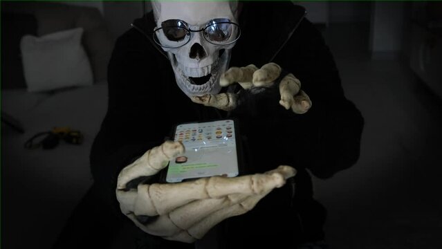 Mystical scary death, skeleton in black cloak, typing message in chat and leaves comments in social networks. Happy Halloween dark background.