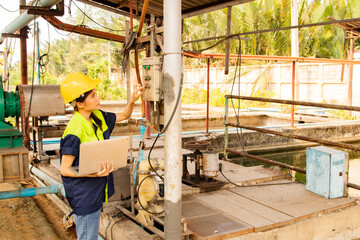 Female technician worker holding laptop inspects control system air pump sanitation station...
