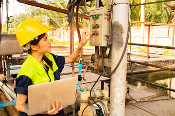 Female technician worker holding laptop inspects control system air pump sanitation station...