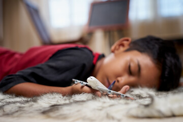 Young boy fall asleep holding airplane toy at home