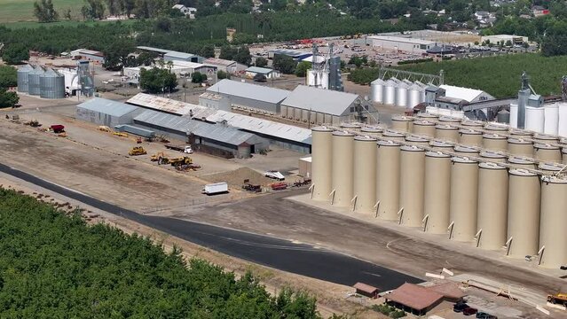 Aerial Sutter California rice grain elevator solar panels slide. Economy based on farming rice, grains, walnuts peaches and cattle ranch. Fields act as wetlands for waterfowl and birds.
